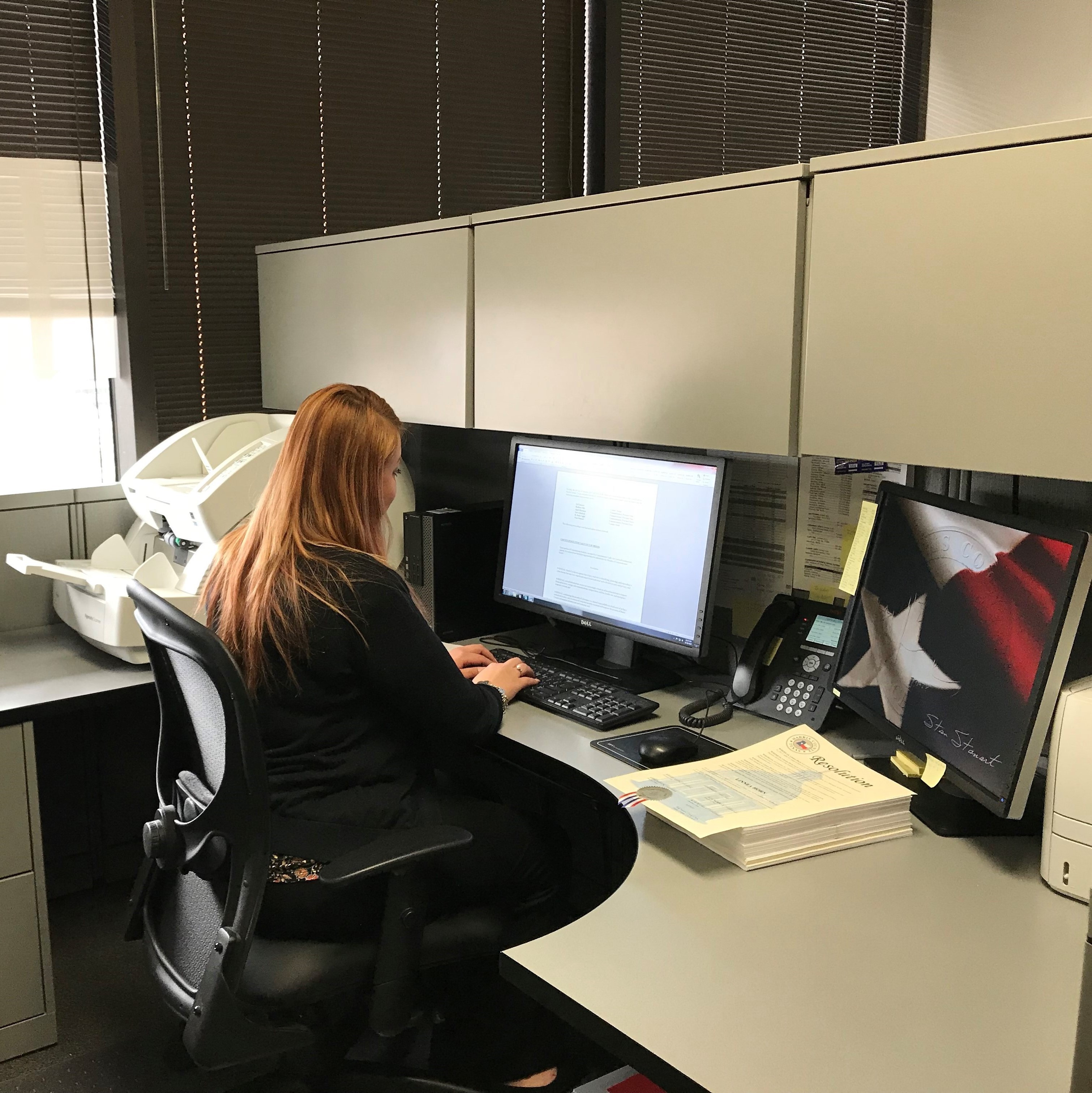 Photo of a clerk answering the phone at her desk