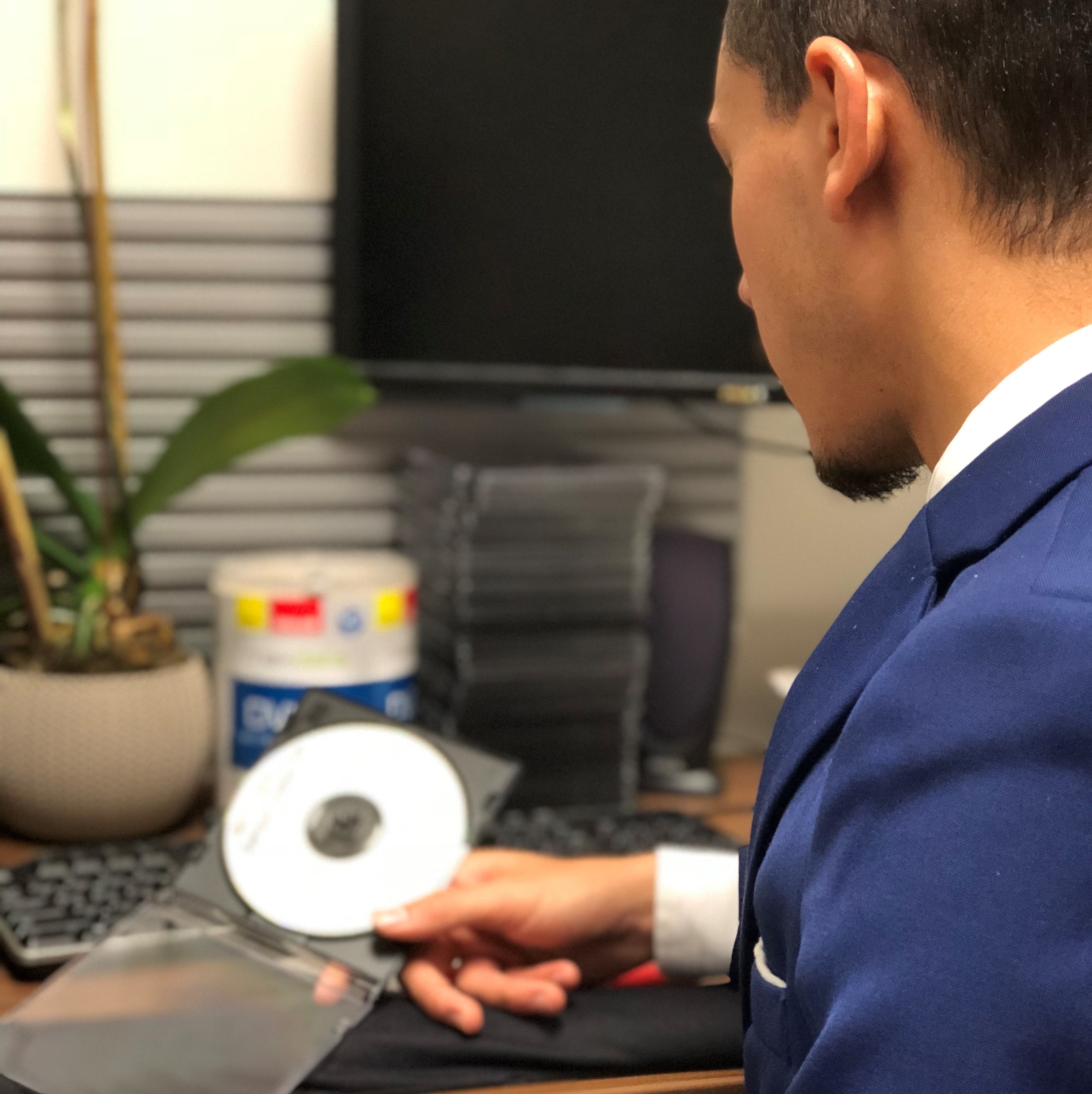 Photo of a clerk at a desk holding a CD