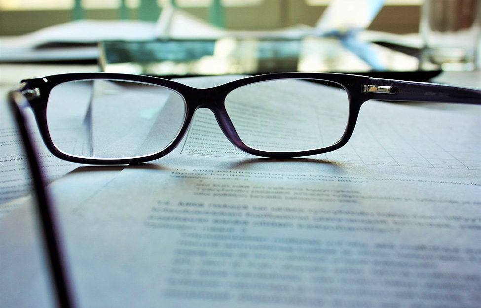 Photo of eye glasses sitting on top of office documents