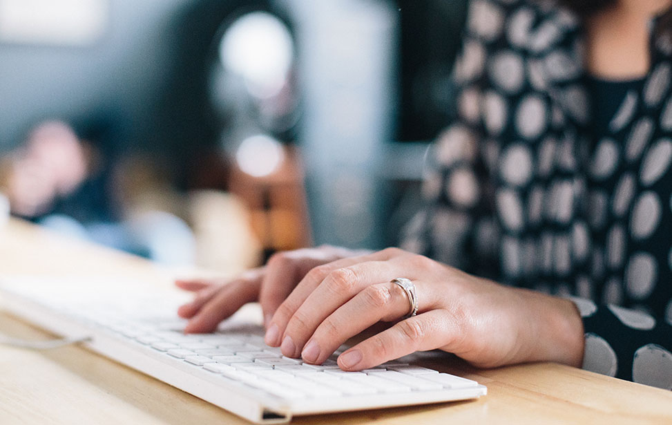 Photo of a woman typing on a keyboard.